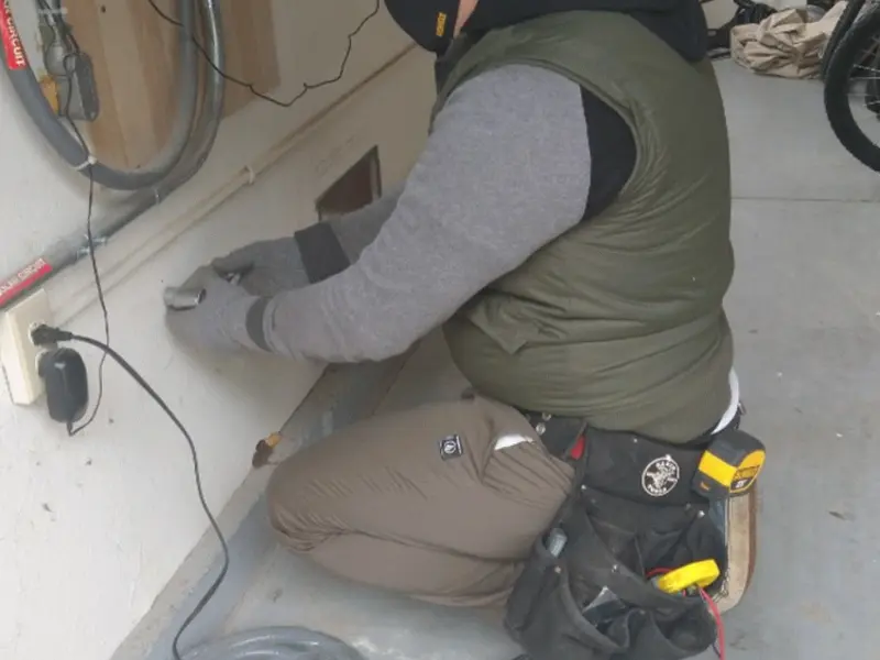 Electrician performing outlet wiring in a Sandston garage